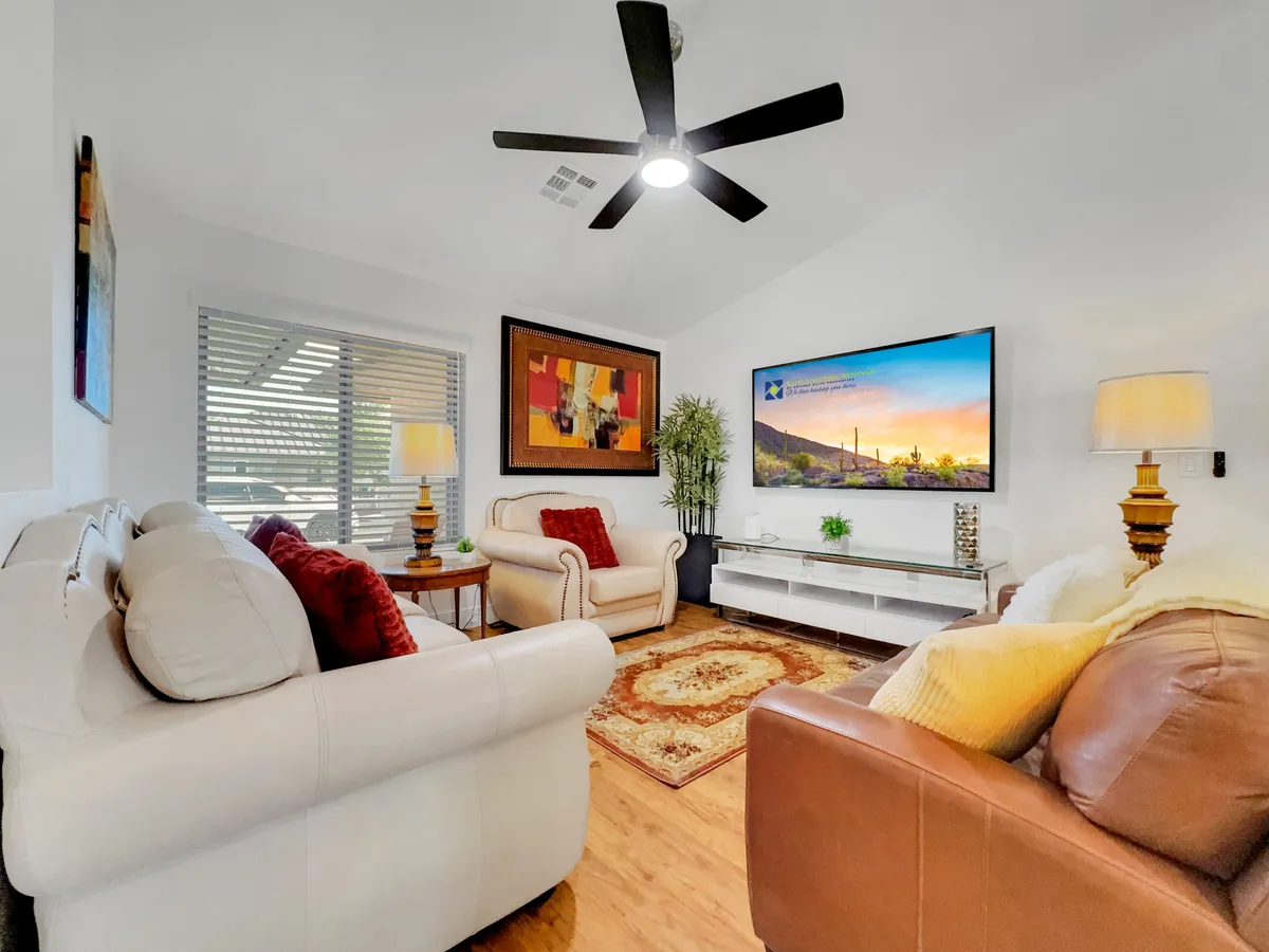 A comfortable living room scene with plush seating, decorative artwork, and a television. The arrangement is perfect for relaxing, watching movies, or entertaining guests, all in a cozy, inviting atmosphere.