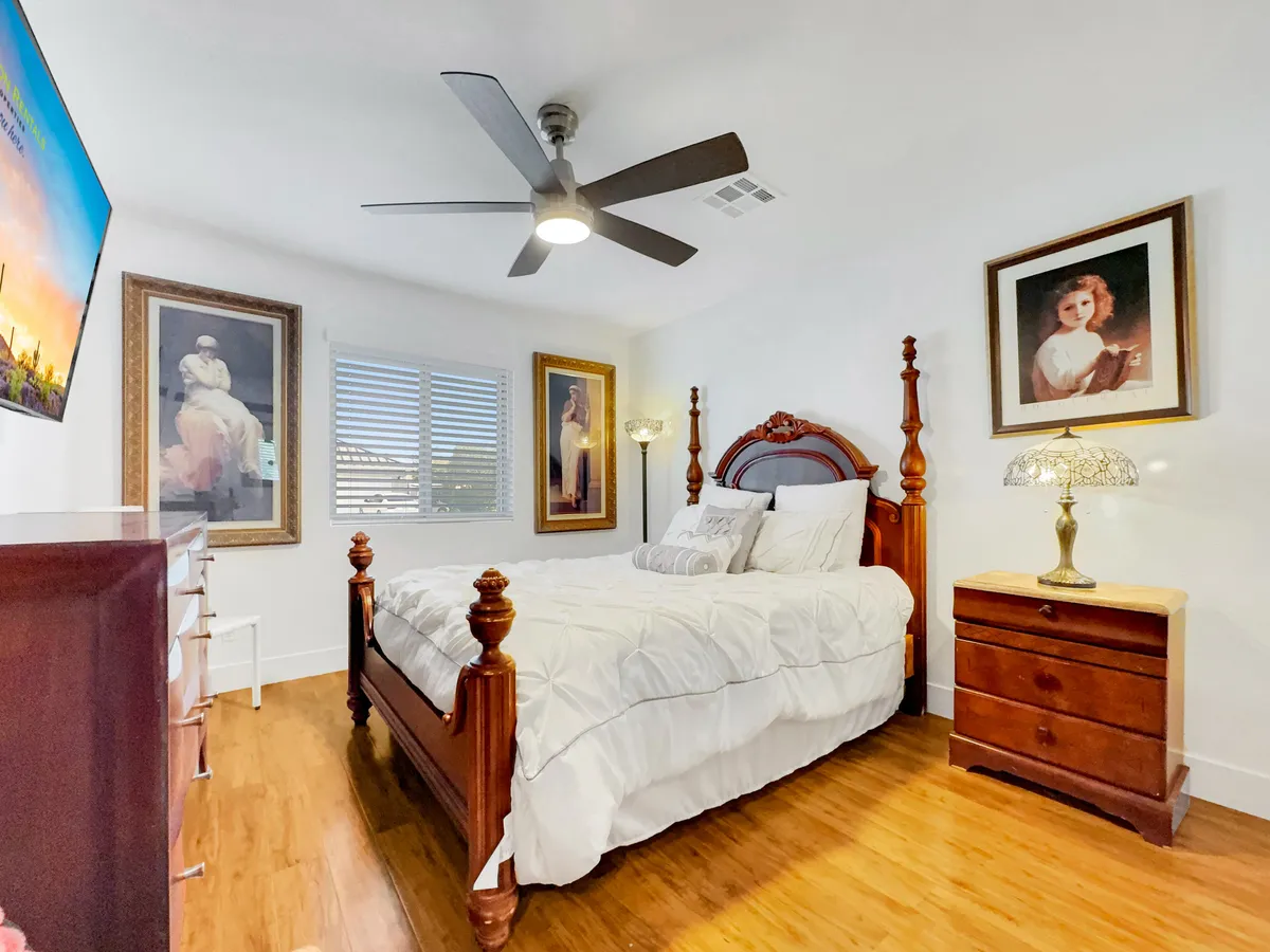 A beautifully appointed bedroom with an ornate headboard, soft lamp lighting, and framed artwork, creating an inviting and restful atmosphere. The space feels tailored for private, intimate relaxation.